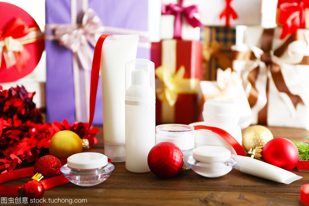 美容化妝品產(chǎn)品與模糊的禮品背景上的圣誕裝飾
